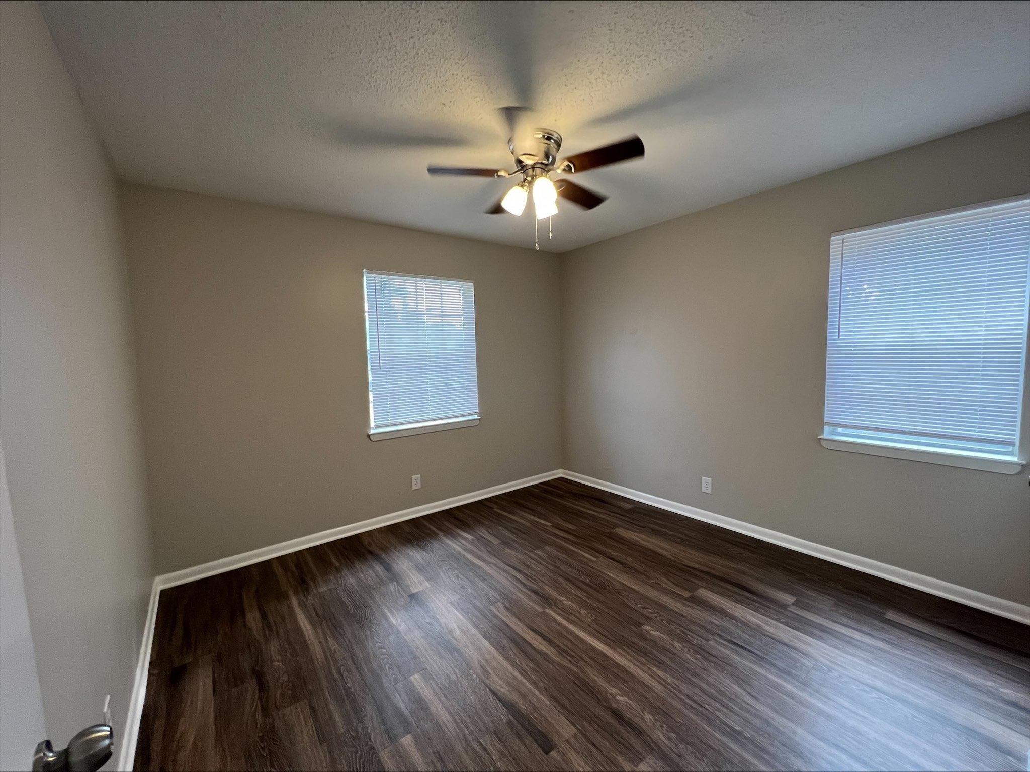 3831 Millbranch Road Memphis, TN 38116 - Photo 10 of 12 a view of an empty room with wooden floor and a window