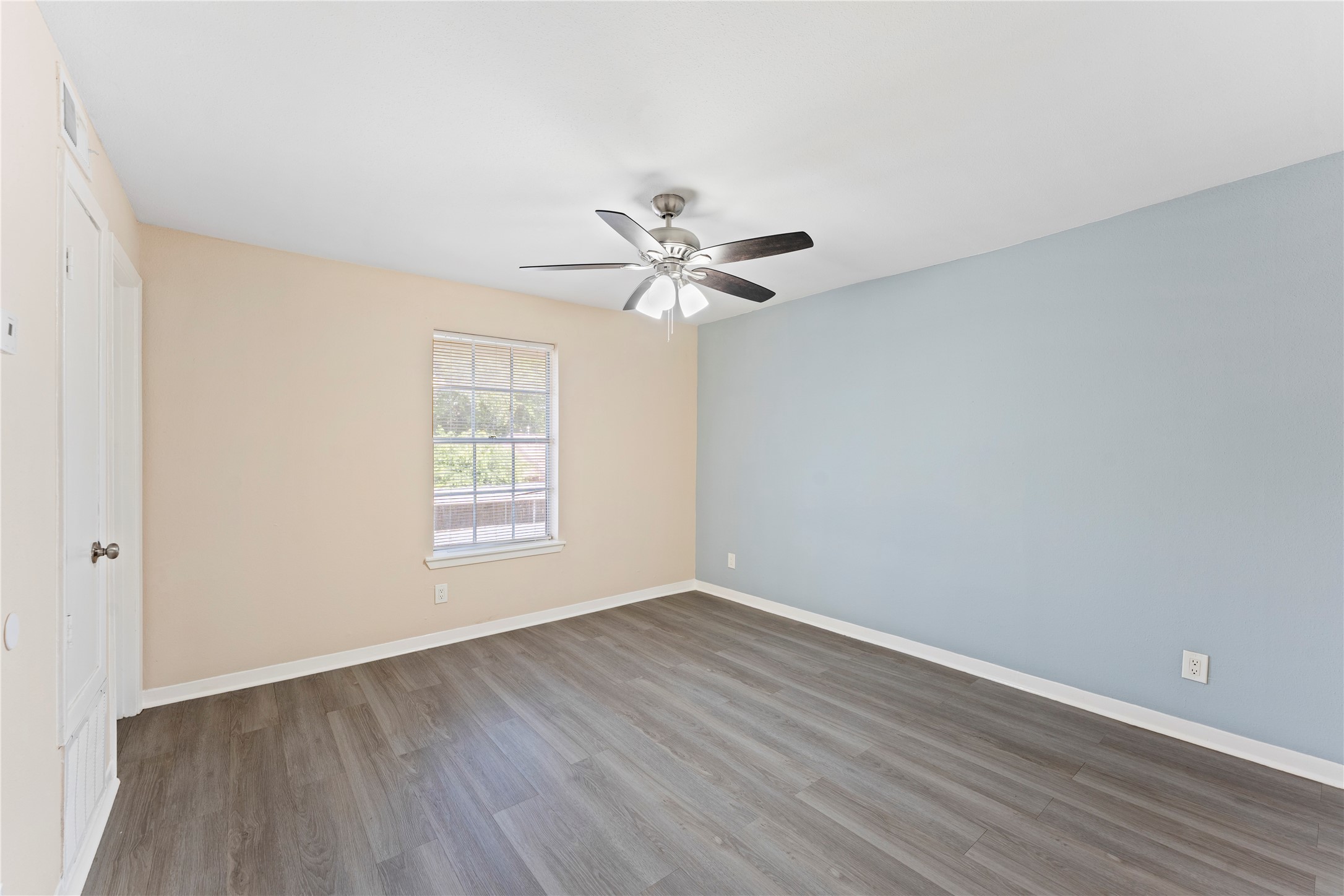 3316 Burke Road, Unit 43 Pasadena, TX 77504 - Photo 10 of 15 a view of an empty room with wooden floor and a ceiling fan
