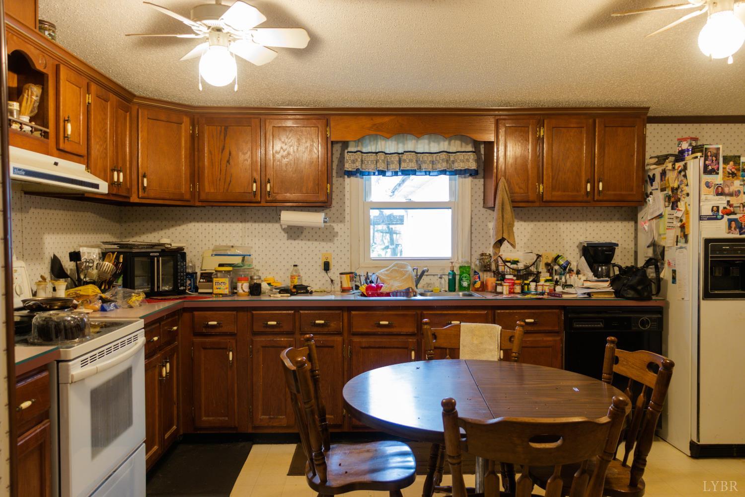 3156 Owens Mill Road Gretna, VA 24557 - Photo 16 of 88 a kitchen with a dining table chairs and cabinets