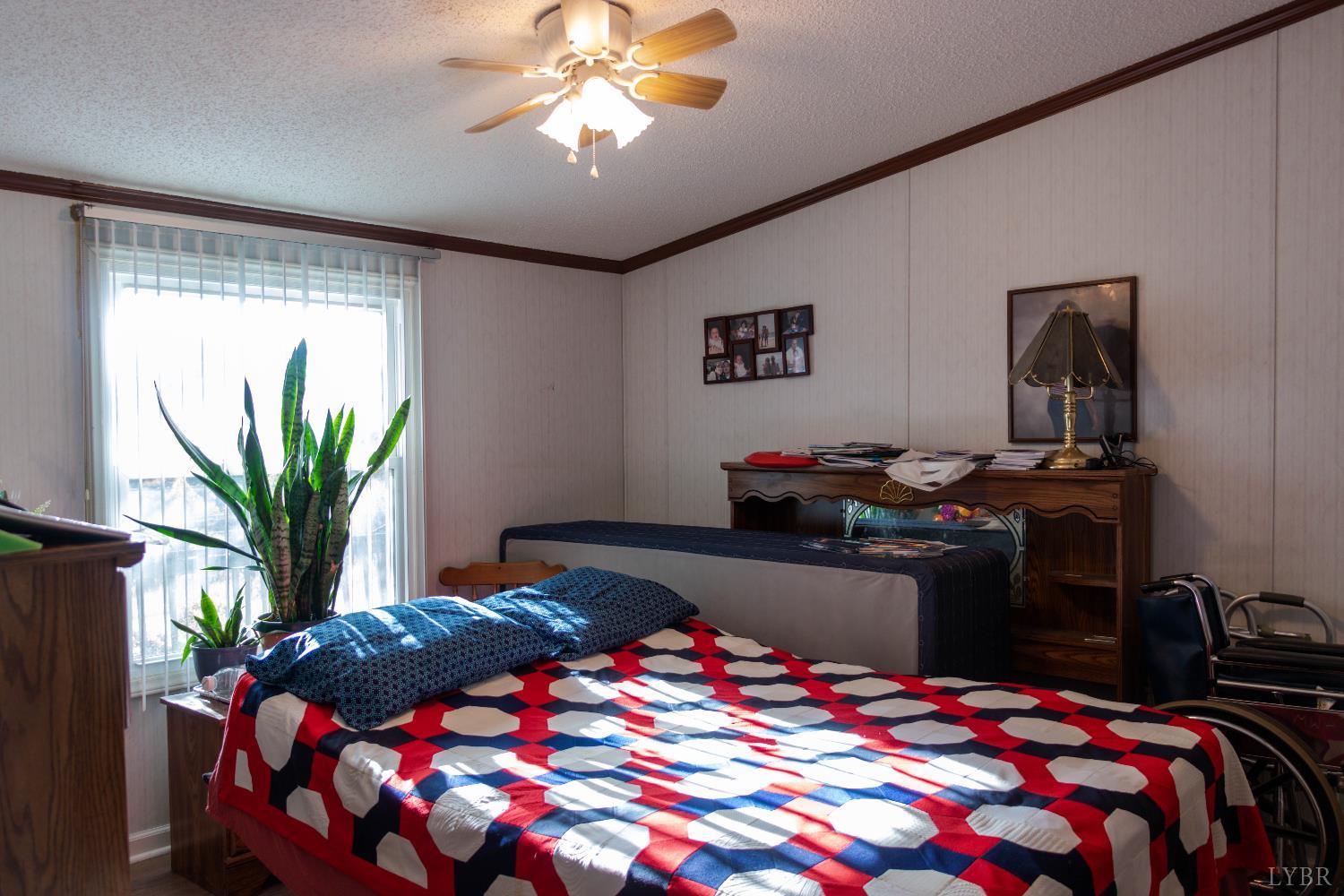3156 Owens Mill Road Gretna, VA 24557 - Photo 27 of 88 a bedroom with a bed and a chandelier