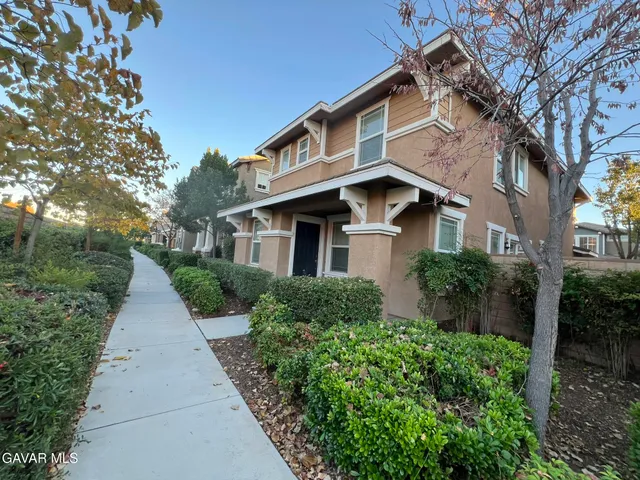 a front view of a house with yard and green space