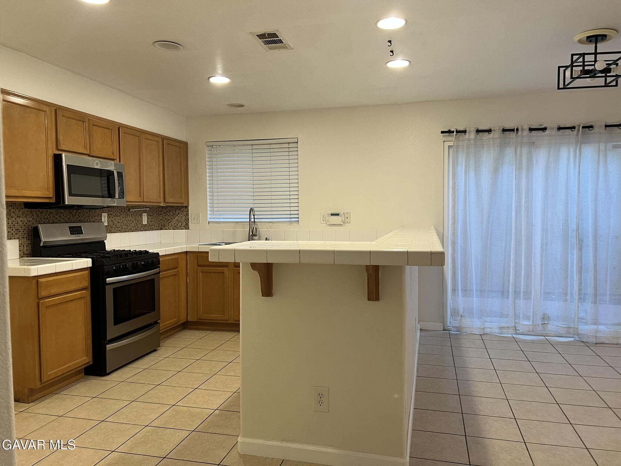 2649 Torres Court Palmdale, CA 93550 - Photo 11 of 33 a kitchen with stainless steel appliances granite countertop a stove a sink and a microwave