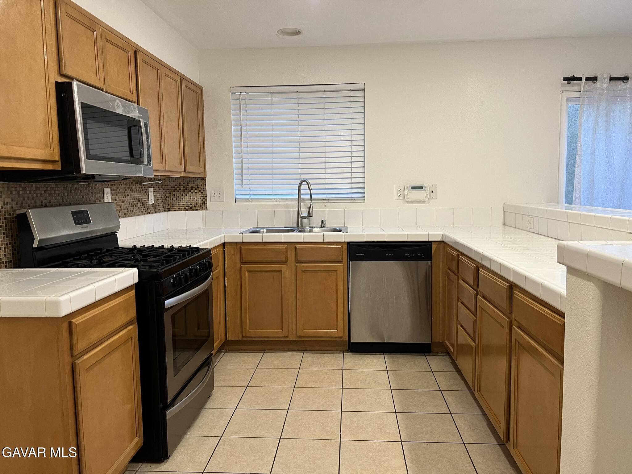 2649 Torres Court Palmdale, CA 93550 - Photo 12 of 33 a kitchen with a sink a stove top oven and cabinets