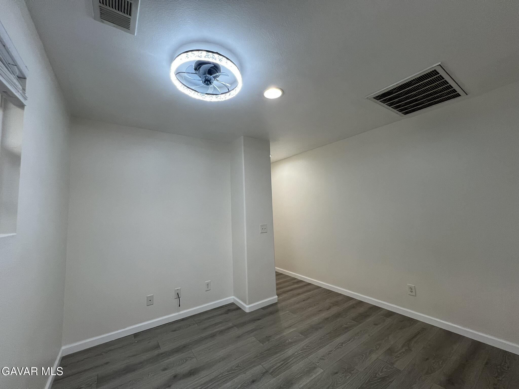 2649 Torres Court Palmdale, CA 93550 - Photo 16 of 33 an empty room with wooden floor and windows