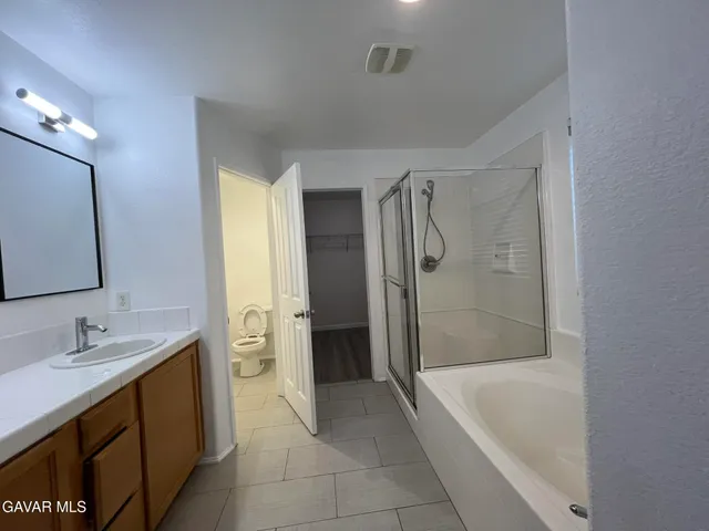 a spacious bathroom with a bathtub sink and mirror