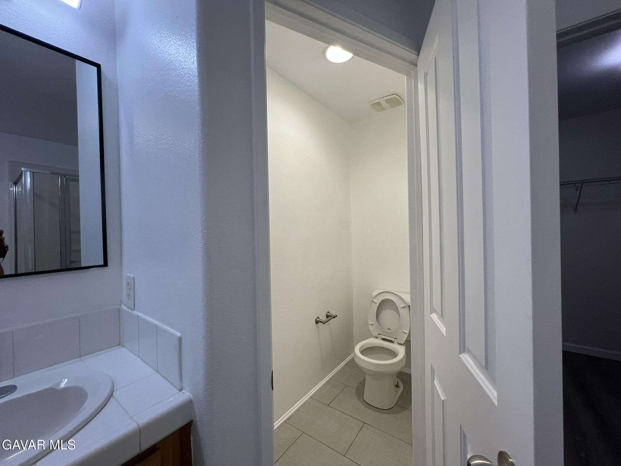 2649 Torres Court Palmdale, CA 93550 - Photo 25 of 33 a bathroom with a toilet a sink and mirror
