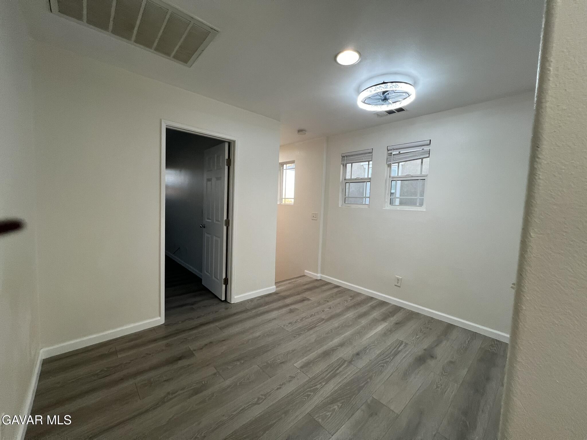 2649 Torres Court Palmdale, CA 93550 - Photo 27 of 33 an empty room with wooden floor and windows