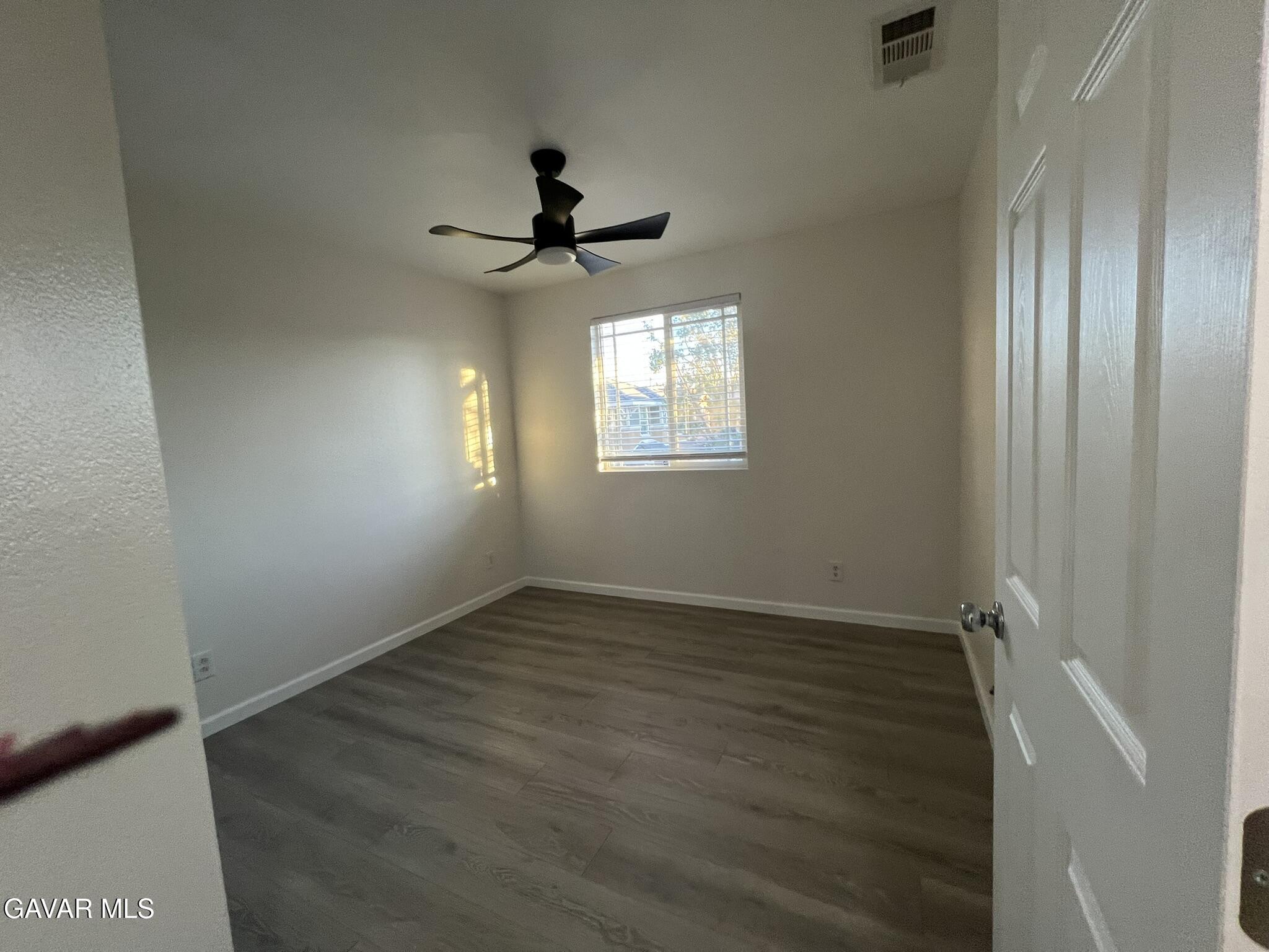2649 Torres Court Palmdale, CA 93550 - Photo 31 of 33 an empty room with wooden floor fan and windows