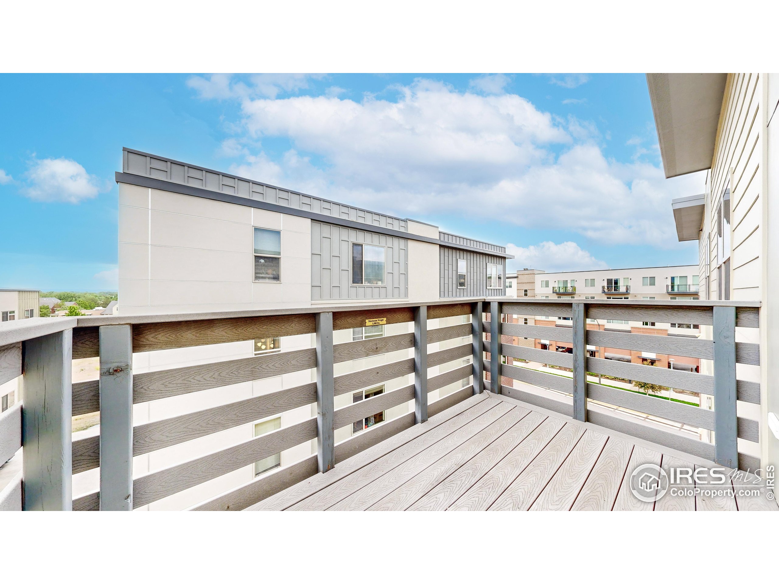 204 Maple Street, Unit 403 Fort Collins, CO 80521 - Photo 22 of 31 a view of a balcony with wooden floor and fence