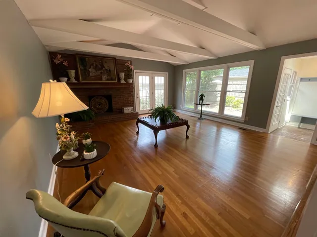 a living room with furniture flowers and a fireplace