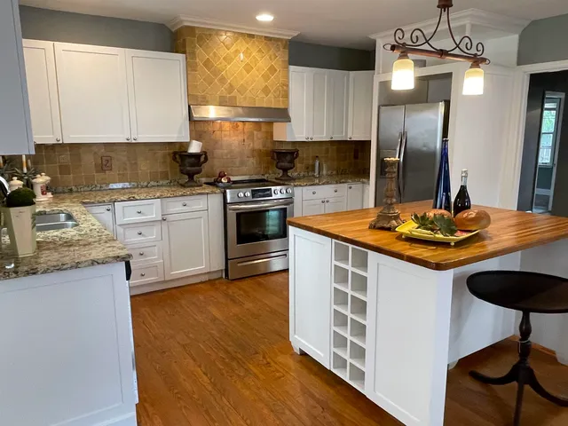 a kitchen with stainless steel appliances granite countertop a sink stove and refrigerator