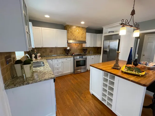 a kitchen with stainless steel appliances granite countertop a sink stove and refrigerator