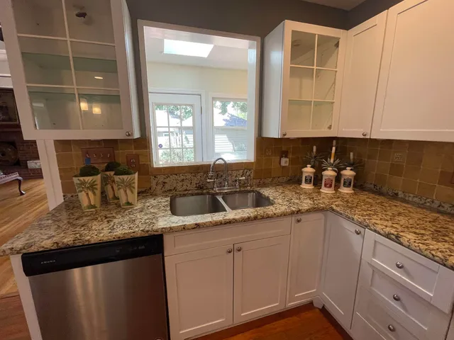 a kitchen with granite countertop a sink and cabinets