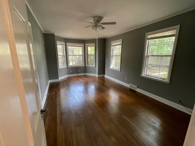a view of a livingroom with wooden floor and a window