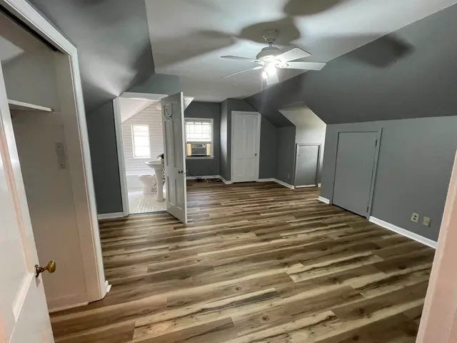 a view of a hallway with wooden floor and chandelier