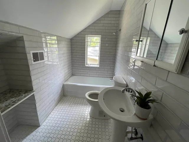 a bathroom with a sink a toilet and bathtub