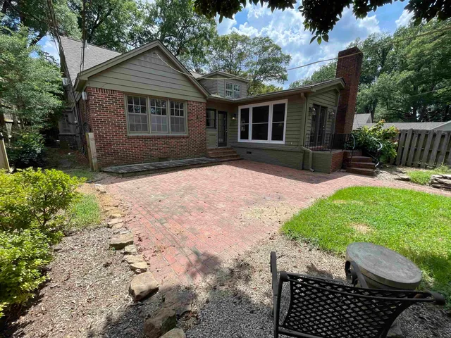 a backyard of a house with table and chairs