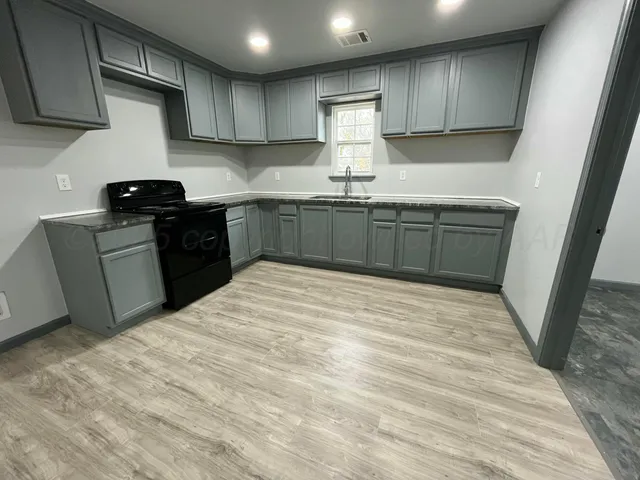 a kitchen with granite countertop a sink stainless steel appliances and cabinets