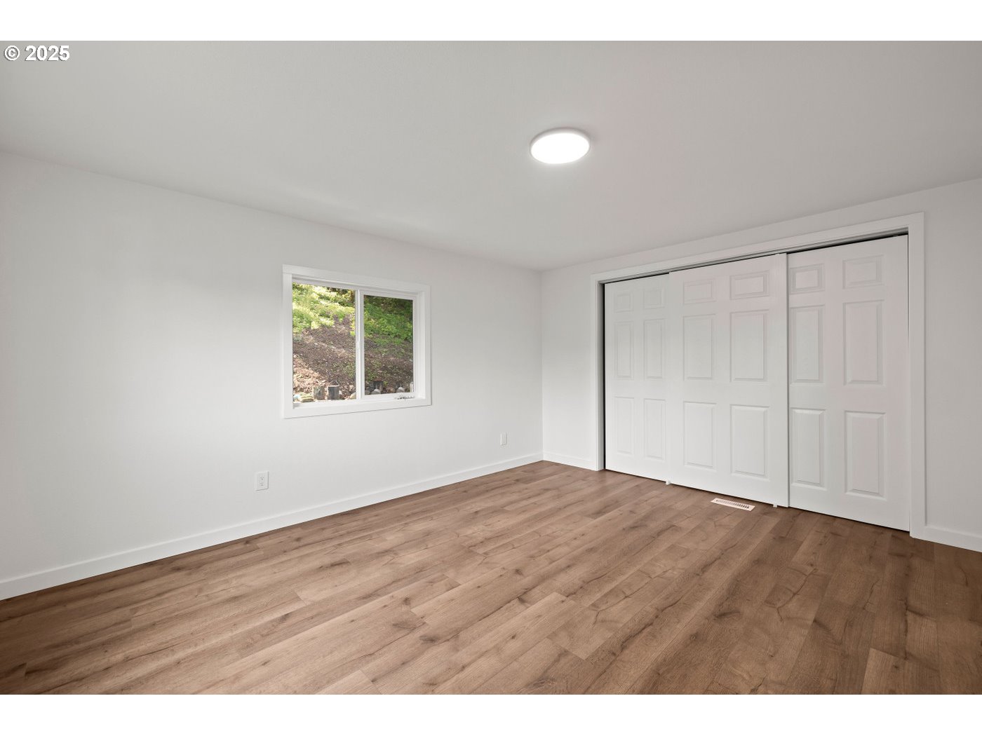 16000 Southeast Powell Boulevard, Unit 34 Portland, OR 97236 - Photo 16 of 28 a view of an empty room with wooden floor and a window