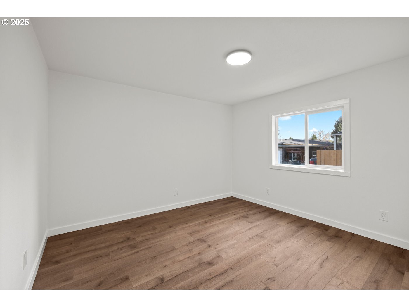 16000 Southeast Powell Boulevard, Unit 34 Portland, OR 97236 - Photo 17 of 28 a view of an empty room with wooden floor and a window