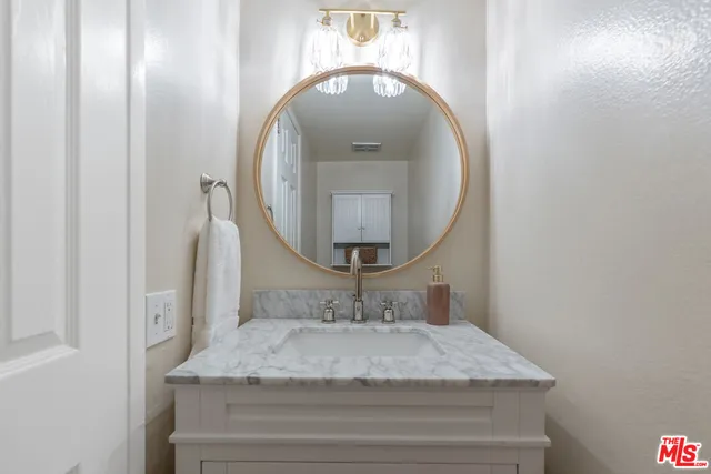 a bathroom with a granite countertop sink and a mirror