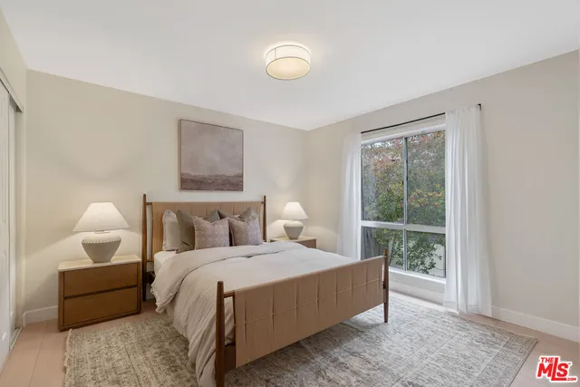 a bedroom with a bed lamp and a window