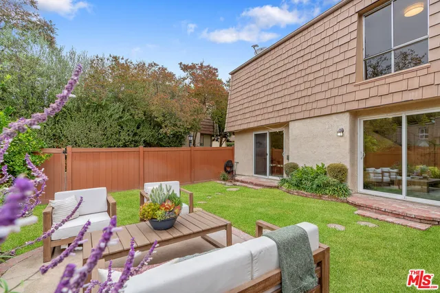 a view of a house with backyard sitting area and garden