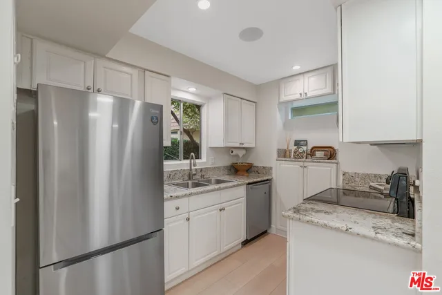 a kitchen with a refrigerator a sink and cabinets