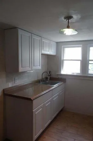 a kitchen with a sink cabinets and window