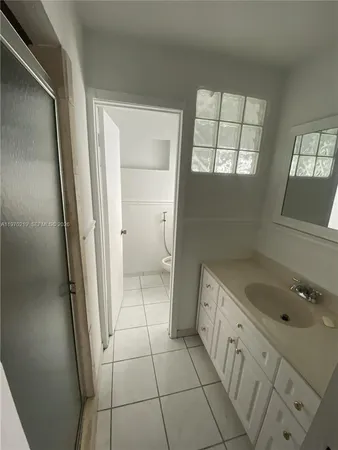 a bathroom with a sink toilet and window