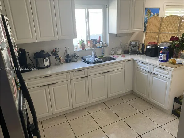 a large white kitchen with a sink and cabinets