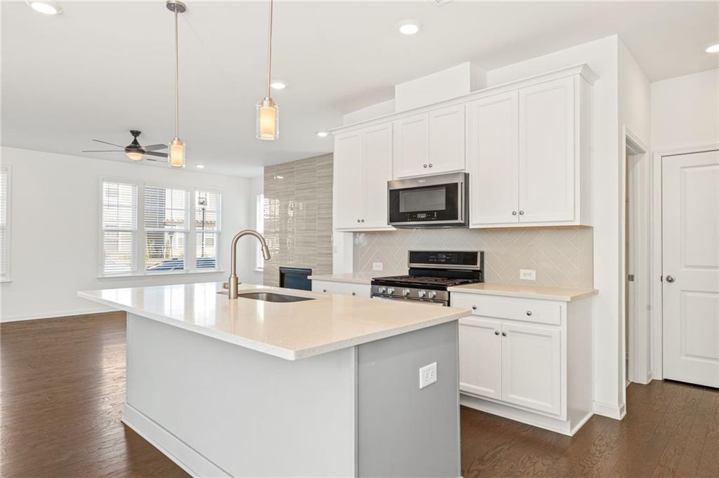4734 Dewitt Drive Duluth, GA 30097 - Photo 12 of 31 a kitchen with stainless steel appliances granite countertop a sink a stove and a wooden floors