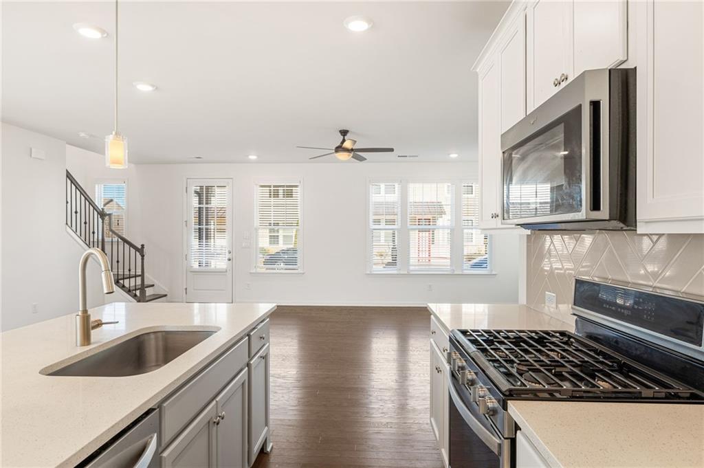 4734 Dewitt Drive Duluth, GA 30097 - Photo 15 of 31 a kitchen with stainless steel appliances a sink a stove and cabinets