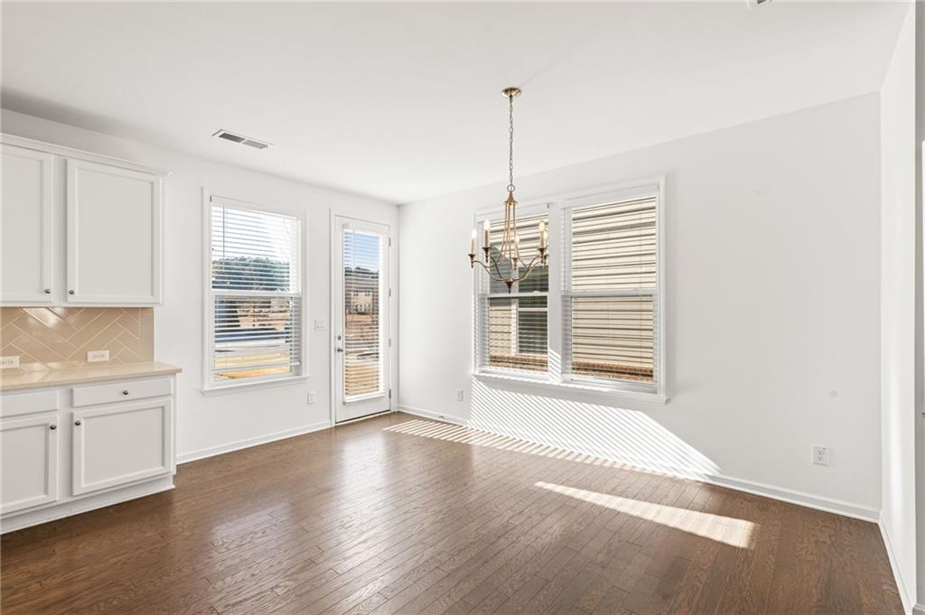 4734 Dewitt Drive Duluth, GA 30097 - Photo 16 of 31 a view of an empty room with a window and wooden floor