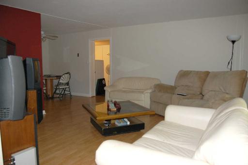 1303 Yarmouth Court, Unit 1303 Schaumburg, IL 60193 - Photo 3 of 11 a living room with furniture a flat screen tv and a table