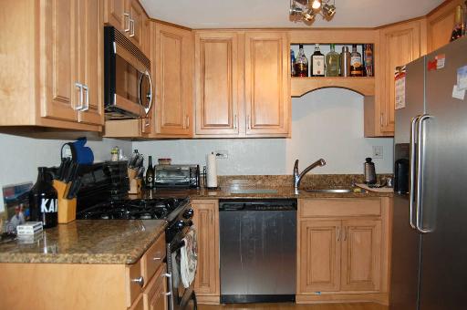 1303 Yarmouth Court, Unit 1303 Schaumburg, IL 60193 - Photo 5 of 11 a kitchen with stainless steel appliances granite countertop a refrigerator a stove a sink and a microwave
