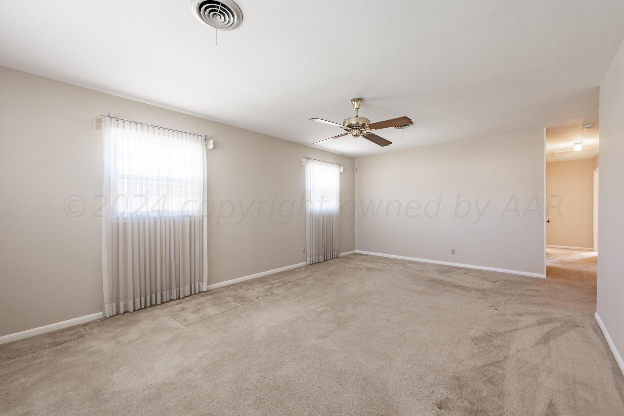 4711 South Lamar Street Amarillo, TX 79110 - Photo 3 of 12 an empty room with windows and fan