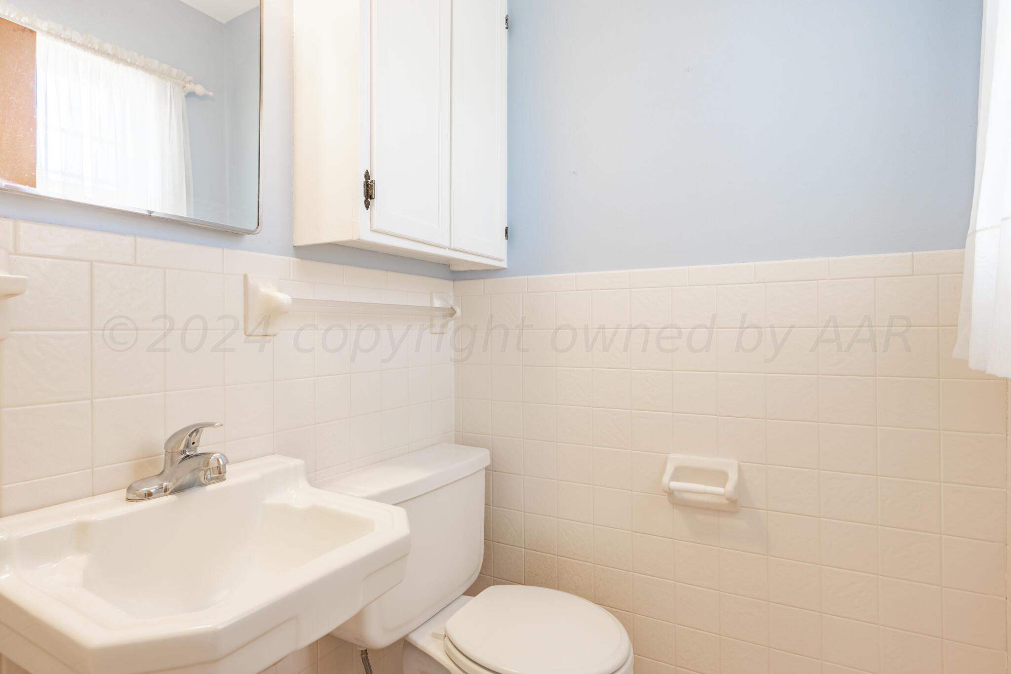 4711 South Lamar Street Amarillo, TX 79110 - Photo 8 of 12 a bathroom with a sink a toilet and mirror
