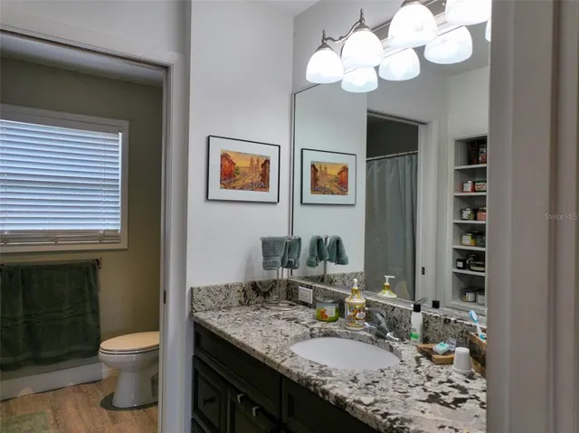 a bedroom with a bed and a flat tv screen on dresser