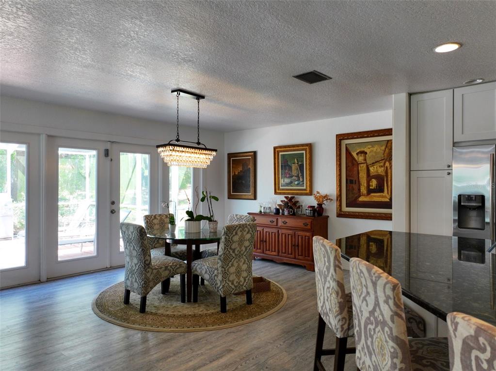 4501 Detour Road Haines City, FL 33844 - Photo 5 of 65 a dining room with wooden floor a chandelier a glass table and chairs