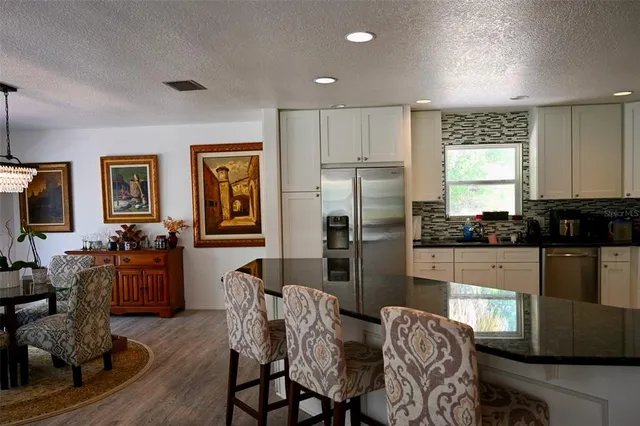 a kitchen with stainless steel appliances granite countertop a refrigerator and a stove top oven