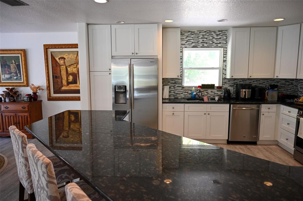 4501 Detour Road Haines City, FL 33844 - Photo 7 of 65 a kitchen with stainless steel appliances granite countertop a sink a stove a refrigerator a washer and cabinets