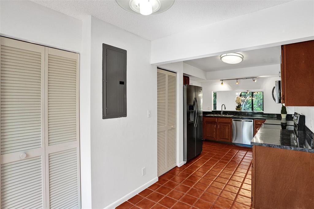 81 Northeast 17th Court Fort Lauderdale, FL 33305 - Photo 12 of 70 a kitchen with stainless steel appliances granite countertop a refrigerator and a sink