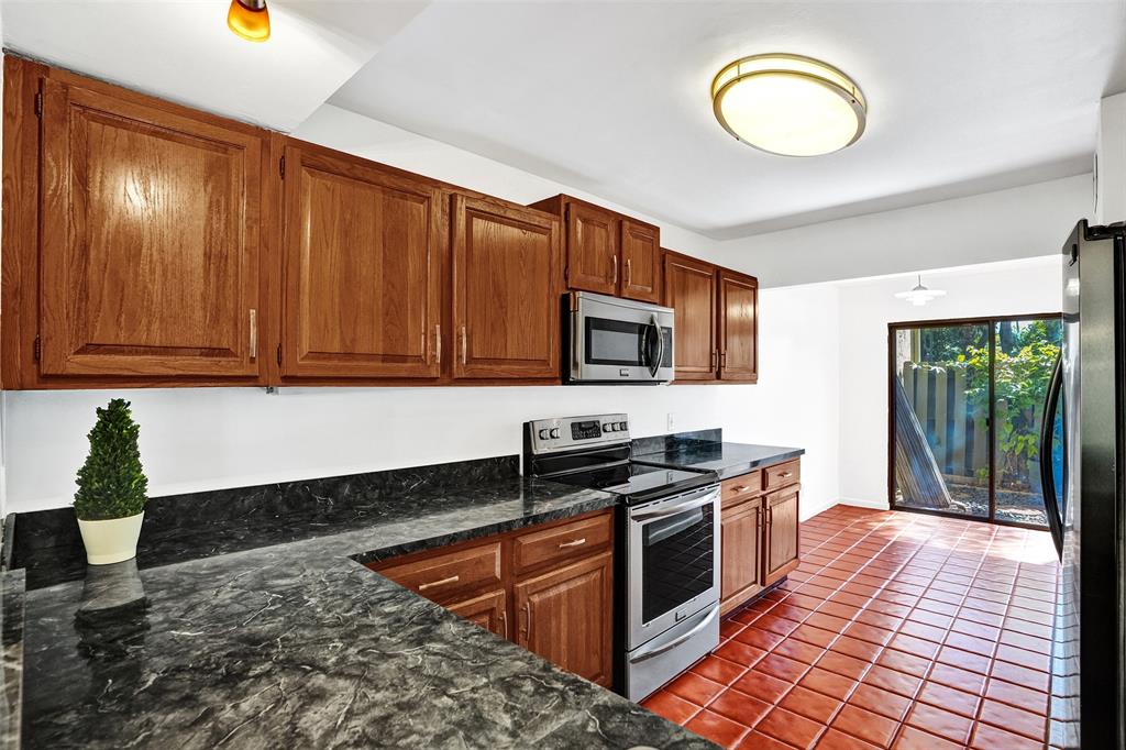 81 Northeast 17th Court Fort Lauderdale, FL 33305 - Photo 15 of 70 a kitchen with stainless steel appliances granite countertop a stove a sink and a microwave