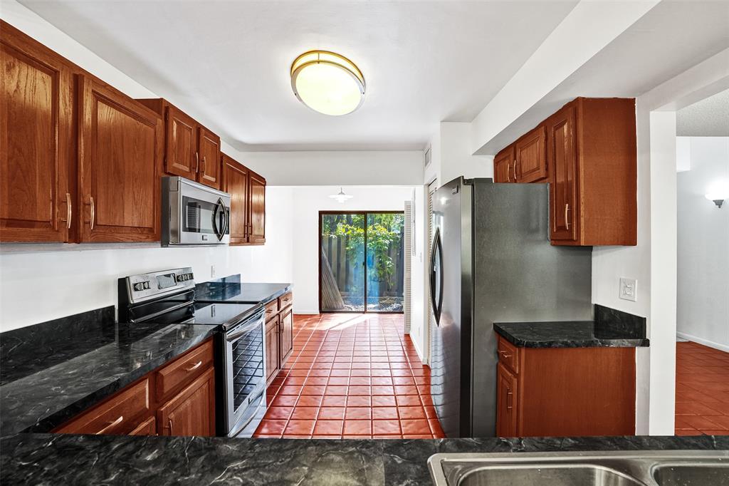81 Northeast 17th Court Fort Lauderdale, FL 33305 - Photo 16 of 70 a kitchen with stainless steel appliances granite countertop a refrigerator a stove top oven a sink and dishwasher