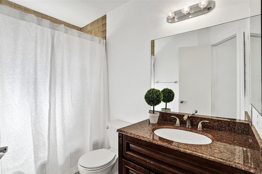 81 Northeast 17th Court Fort Lauderdale, FL 33305 - Photo 46 of 70 a bathroom with a granite countertop sink a toilet and a mirror