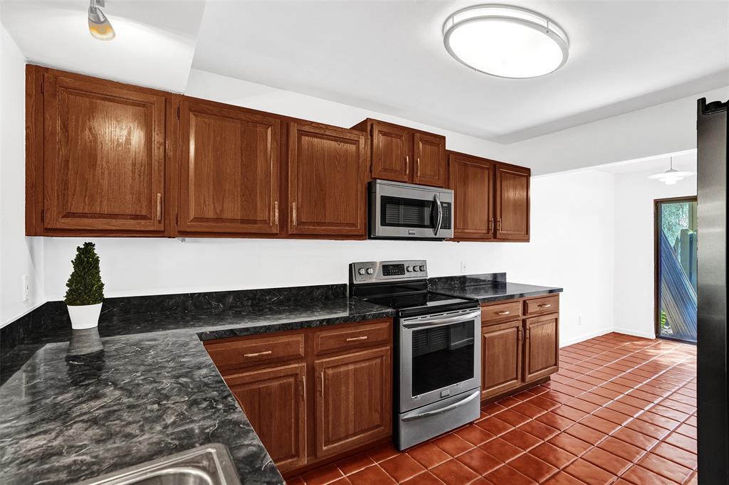 81 Northeast 17th Court Fort Lauderdale, FL 33305 - Photo 9 of 70 a kitchen with stainless steel appliances granite countertop a stove a sink and a microwave