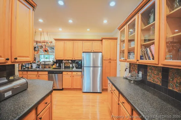 a kitchen with stainless steel appliances granite countertop a sink a stove and cabinets