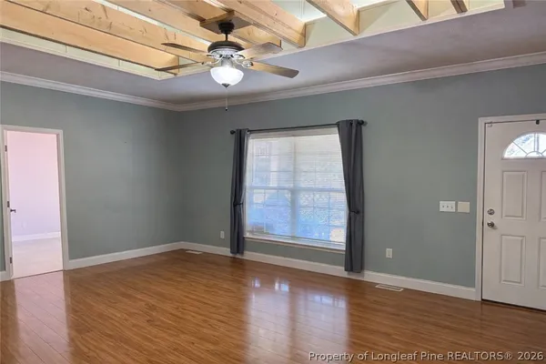 an empty room with wooden floor and window