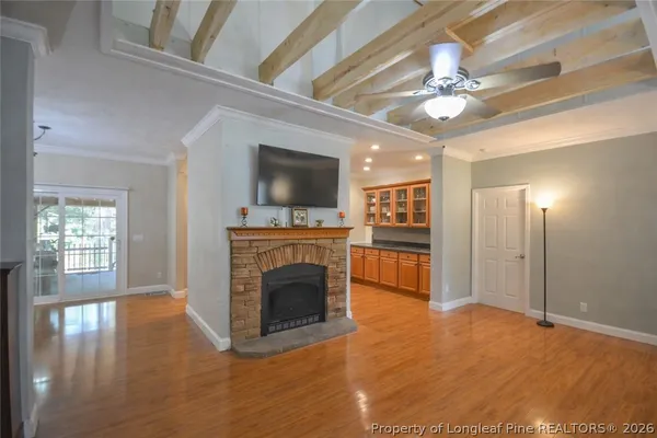 a view of a livingroom with a fireplace a chandelier and wooden floor